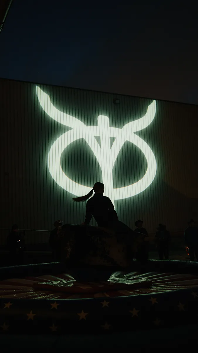 cinematic image of a freiheit.com member riding the bull infront of the freiheit.com x Yellowstone logo